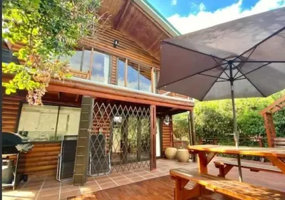 a patio with a table and an umbrella at Milkwood Cabin Getaway in Lake Marina
