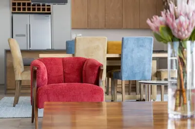 a dining room with a red chair and a table at Benguela Cove - Coastal Retreat in Hermanus