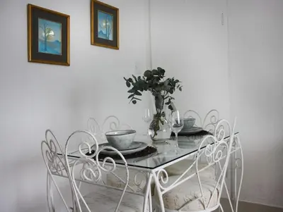 a dining room table with a vase on top of it at Eucalyptus Cottage in Cape Town