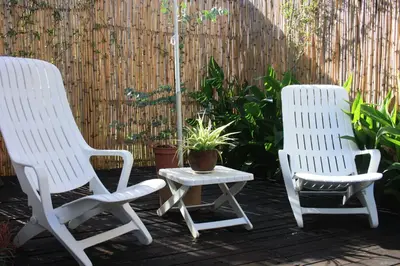 two white chairs and a table on a patio at Eucalyptus Cottage in Cape Town