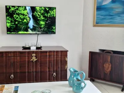 a living room with a tv on top of a dresser at Eucalyptus Cottage in Cape Town