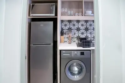 a kitchen with a washing machine and a microwave at Stylish Studio Stellenbosch - Airconditioned in Stellenbosch