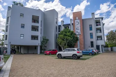 a white building with cars parked in front of it at Stylish Studio Stellenbosch - Airconditioned in Stellenbosch
