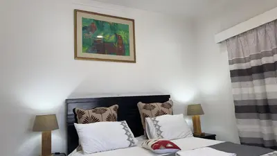 a bedroom with a bed and a picture on the wall at MELJAA STAR Guesthouse in Cape Town