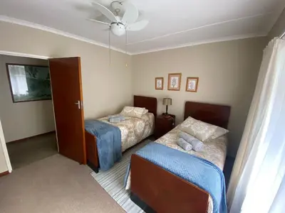 a bedroom with two beds and a ceiling fan at Somstuis in Hermanus