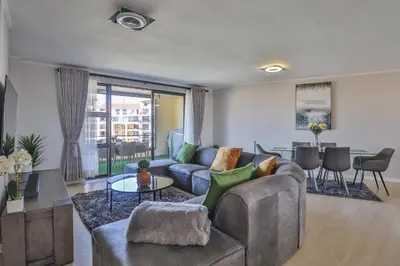 a living room with a couch and a table at 405 Portofino Eyrie Holiday Apartments in Cape Town