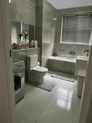 a bathroom with a toilet and a washing machine at 102 Palma Eyrie Holiday Apartments in Cape Town