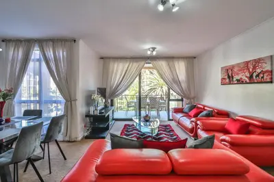 a living room with a red couch and a table at 102 Palma Eyrie Holiday Apartments in Cape Town