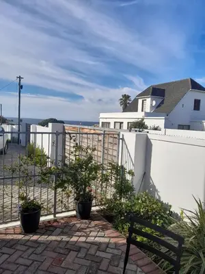 a bench sitting in front of a white fence at Marine View in Hermanus