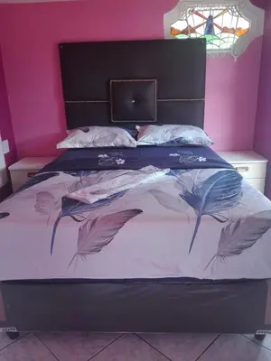 a bedroom with a large bed with feathers on it at ALEXIA LODGE & SPA in Cape Town