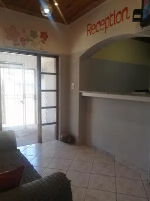 a living room with a couch and a sign that reads reception at ALEXIA LODGE & SPA in Cape Town