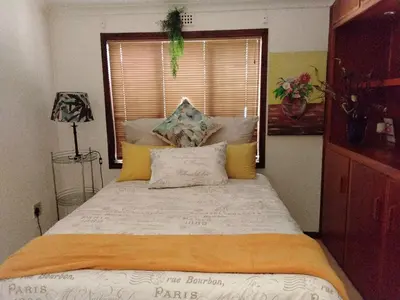 a large bed in a bedroom with a window at THE TREE HOUSE in Grabouw