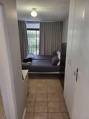 a bedroom with a bed and a window in a room at Fynbosrus on Grotto in Hermanus