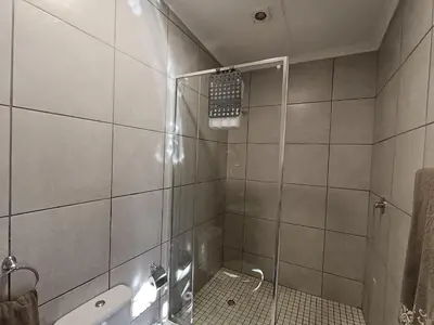 a shower with a glass door in a bathroom at Dalau on Main in Paarl