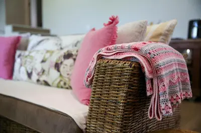 a wicker chair with a blanket on a couch at Ivy House - Super Spacious Spot- Somerset West in Somerset West