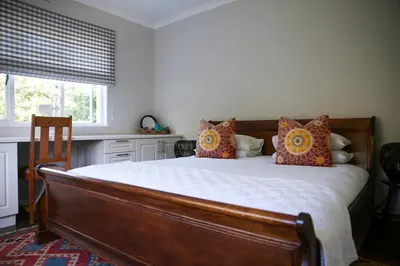 a bedroom with a large bed with orange pillows at Ivy House - Super Spacious Spot- Somerset West in Somerset West