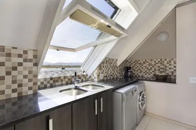 a kitchen with a sink and a skylight at Dolphin Beach H301 by Host Agents in Bloubergstrand