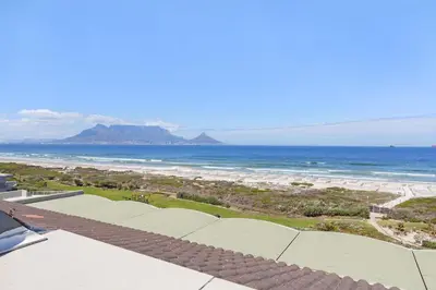 a view of the beach from the balcony of a resort at Dolphin Beach H301 by Host Agents in Bloubergstrand