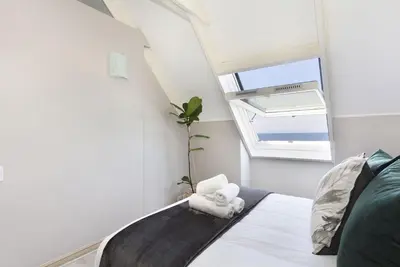 a small bedroom with a bed with a window at Dolphin Beach H301 by Host Agents in Bloubergstrand