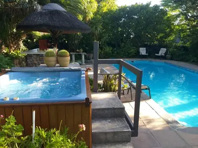 a pool with a hot tub and stairs next to it at Santika Getaway Cottage Stellenbosch in Stellenbosch