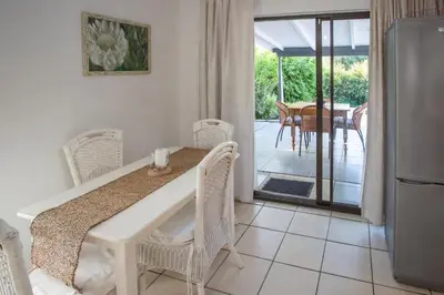 a kitchen and dining room with a table and chairs at Santika Getaway Cottage Stellenbosch in Stellenbosch