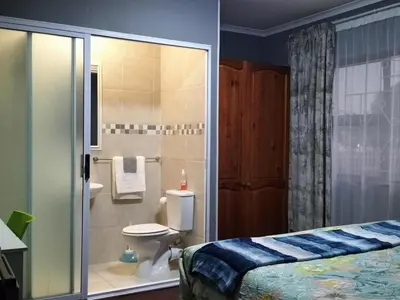 a bathroom with a toilet and a glass shower at Step-by-Step Self-Catering and B&B in Bellville