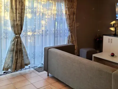 a living room with a couch and a large window at Step-by-Step Self-Catering and B&B in Bellville