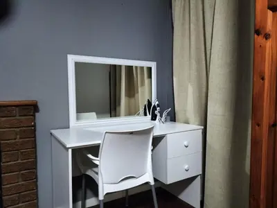 a white desk with a mirror and a white chair at Step-by-Step Self-Catering and B&B in Bellville