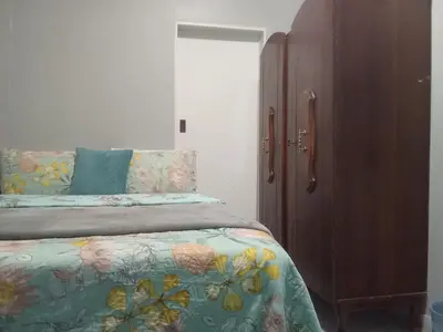 a bedroom with a bed and a wooden cabinet at Step-by-Step Self-Catering and B&B in Bellville