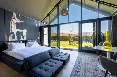 a bedroom with a bed and a couch and a table at La Villa in Franschhoek