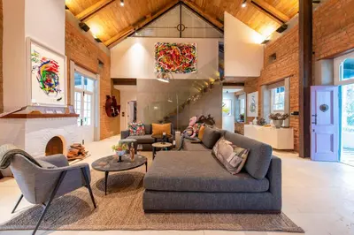 a living room with a couch and chairs and a fireplace at La Villa in Franschhoek