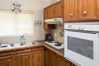 a kitchen with a white stove top oven next to a sink at 5 Lantra in Strand