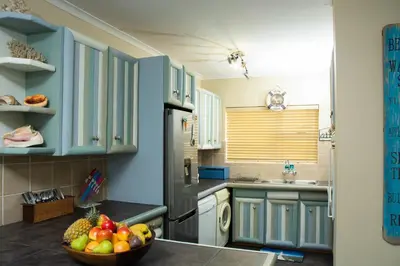 a kitchen with blue cabinets and a bowl of fruit on the counter at 5 Lantra in Strand