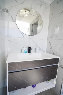 a white bathroom with a sink and a mirror at Ocean Vibes in Cape Town