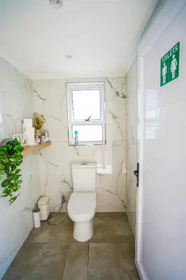 a bathroom with a toilet and a window at Ocean Vibes in Cape Town