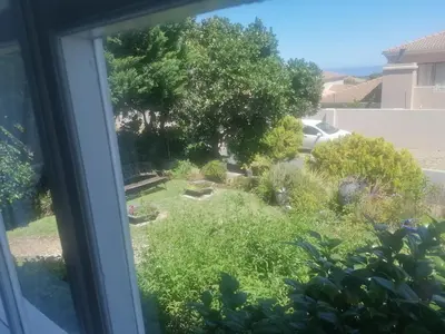 a view of a garden from a window at Hermanus Sea view room in Hermanus