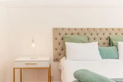 a bedroom with a bed with a tufted headboard at Secure and Modern 2Bed Apartment in Cape Towns Charming Rondebosch in Cape Town
