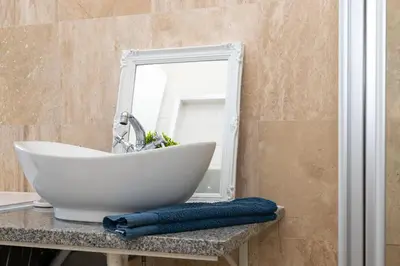 a bathroom with a white sink and a mirror at Secure and Modern 2Bed Apartment in Cape Towns Charming Rondebosch in Cape Town