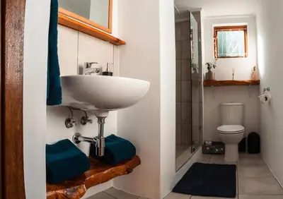 a bathroom with a sink and a toilet at The Salty Surf Shack in Cape Town