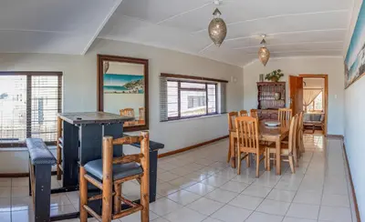 a kitchen and dining room with a table and chairs at The Salty Surf Shack in Cape Town