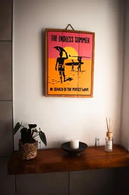 a sign on a wall above a wooden shelf at The Salty Surf Shack in Cape Town