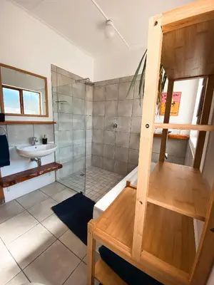 a bathroom with a shower and a sink at The Salty Surf Shack in Cape Town