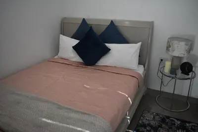 a bedroom with a bed with blue and white pillows at Langbeentjie Inn Two Point O in Cape Town