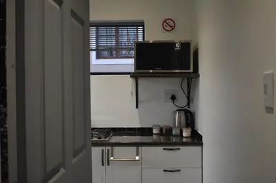 a small kitchen with a microwave on a counter at Langbeentjie Inn Two Point O in Cape Town
