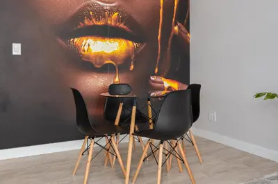 a table and chairs in a room with a poster of a mouth at Burmeister on Park 007 in Cape Town