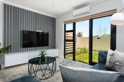 a living room with a tv and a couch and a table at Burmeister on Park 007 in Cape Town
