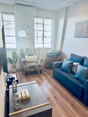 a living room with a blue couch and a chair at Kaneel Suiker - Paarl - Self Catering Apartment in Paarl