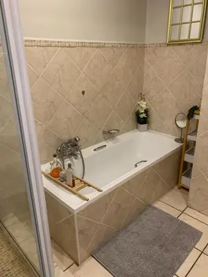 a bath tub in a bathroom with a shower at The Lazy Expat - Paarl - Self Catering Apartment in Paarl