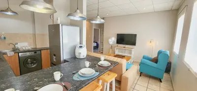 a kitchen and living room with a table and blue chair at The Tipsy Expat - Paarl - Self Catering Apartment in Paarl