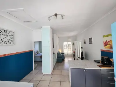 a kitchen with a counter and a living room at A spacious Haven near Bloubergstrand beach in Cape Town